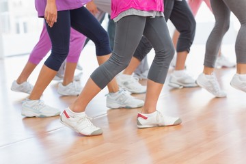 Low section of fitness class doing pilates exercise