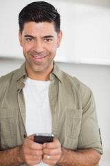 Smiling man text messaging