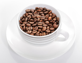A cup full of coffee beans on a white background