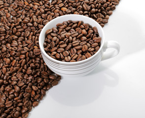 A cup of coffee beans on the edge of diagonal coffee beans shape