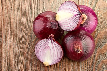 Fresh red onions on a wooden background