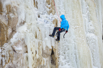 Young man climbing the ice