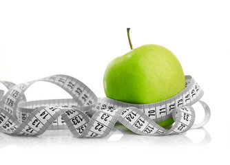 Measuring tape wrapped around a green apple