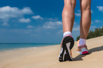 Close up of feet of a runner running in the beach