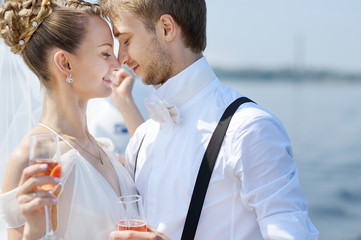 Happy bride and groom drinking champagne