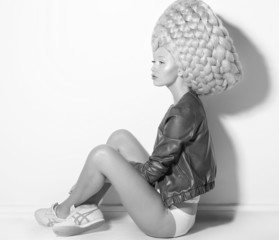Vogue. Fanciful Woman Fashion Model in Creative Periwig sitting