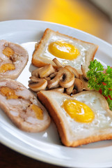 English breakfast: fried egg, bacon, beans and toast on a plate close-up.