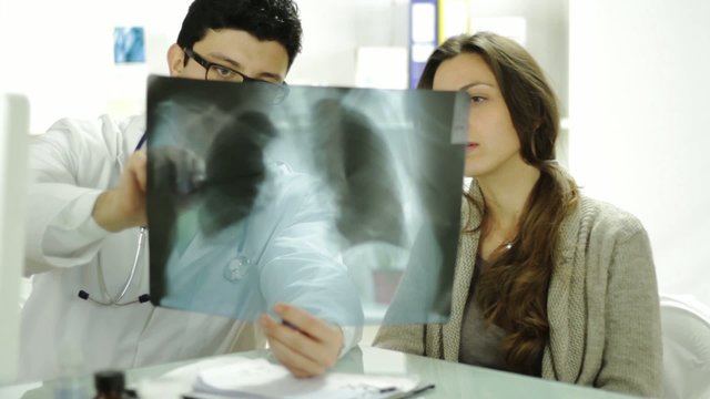 Doctor Explaining Treatment to Young Woman Worried Xray