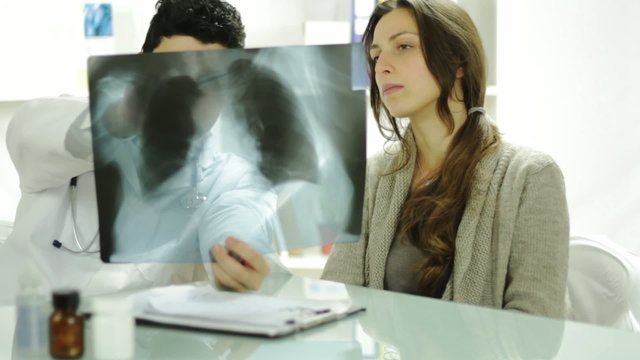 Young Doctor Explaining Treatment to Female Patient Xray