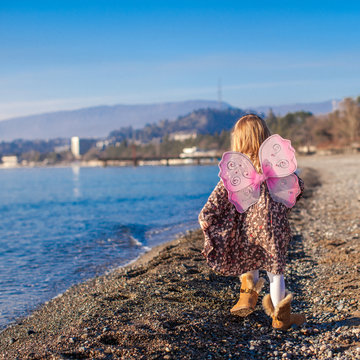 Adorable Little Girl With Butterfly Wings Running Along The