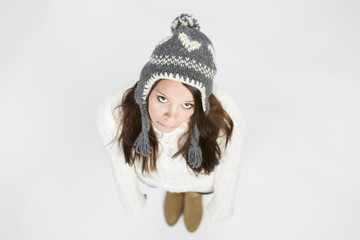 Cute girl in winter clothes looking up and lovely smiling. - obrazy, fototapety, plakaty