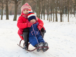 Fototapeta na wymiar Two happy kids on the sled