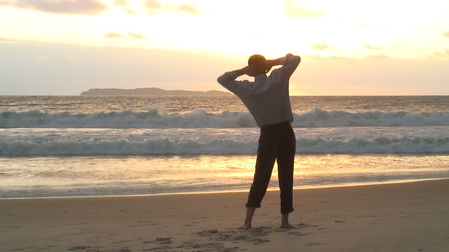 Gesch&auml;ftsmann entspannt am Strand bei Sonnenaufgang.