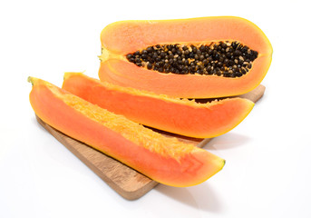 Half cut and whole papaya fruits on white background