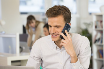 Happy Businessman in office answering the phone