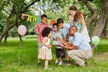 Father lights candle on birthday cake with lighter