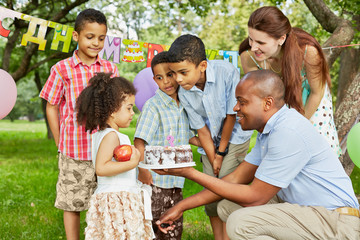 Father gives birthday cake with burning candle on it