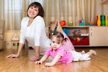 Mother and her child doing exercises together in home interior