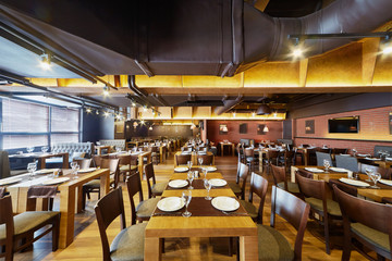 Interior of cafe with wooden furniture and walls of red bricks