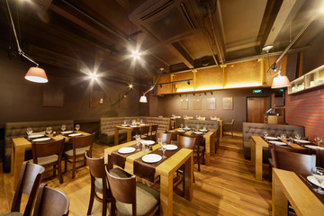 Fototapeta na wymiar Interior of room in restaurant with wooden furniture