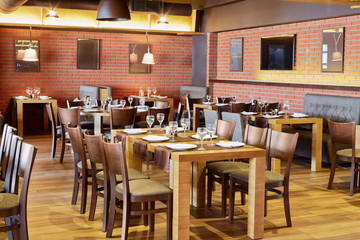 Restaurantraum mit Holzmöbeln und Wänden aus roten Backsteinen