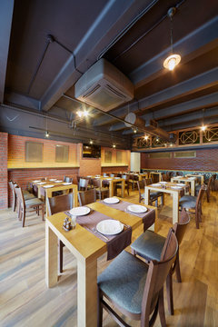 Interior of cafe with wooden furniture and walls of bricks