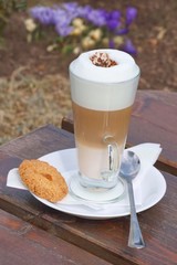 Coffee with milk in a glass cup and cake