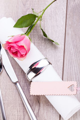 romantisch gedeckter tisch mit silberbesteck und einer rose