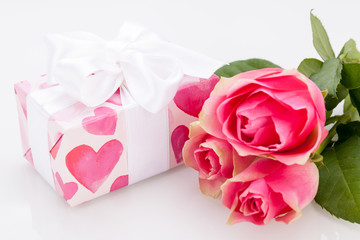 kleines verpacktes geschenk mit herzen und rosen in pink
