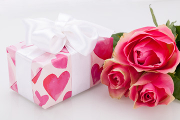 kleines verpacktes geschenk mit herzen und rosen in pink
