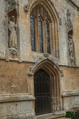Obraz premium Wooden church door and stained arched window, England