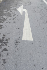 Arrow sign on asphalt surface