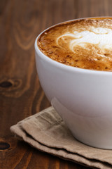 freshly made cup of cappuccino with abstract latte art