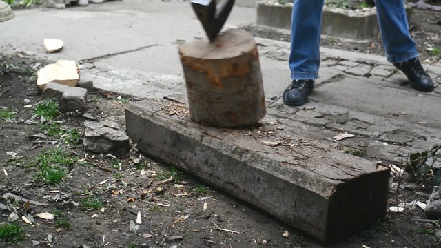 Lumber jack man chopping wood logs with ax. Making firewood