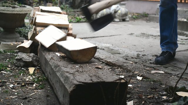 Lumber jack man chopping wood logs with ax. Making firewood