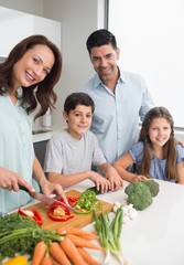 Family chopping vegetables in the kitchen