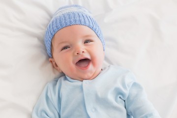 Portrait of cheerful baby in bed