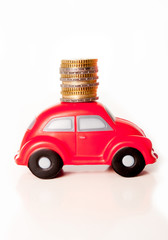 red toy car on a white background with coins on roof