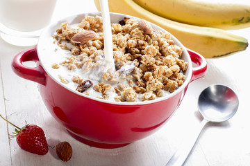 Pour milk into the bowl for healthy breakfast