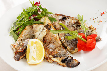 Grilled fish fillet with tomato and lemon