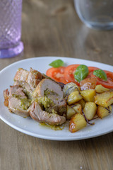 Stuffed pork fillet with tomatoes and basil on the side on an ol