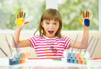 Little girl is drawing using pencils