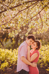 Fototapeta premium Portrait of young couple in flowering park