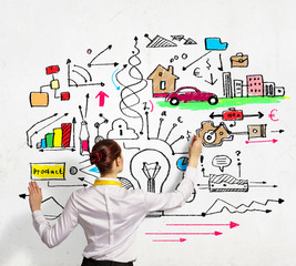 Businesswoman drawing on wall