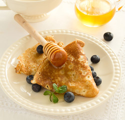 Delicious pancakes with berries and honey
