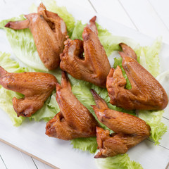 Smoked chicken wings and salad leaves, view from above