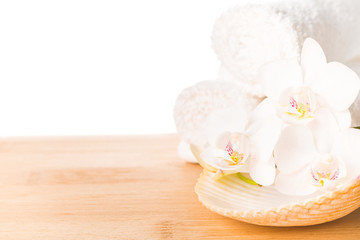 Spa still life with white orchid, shell and towel on wood backgr