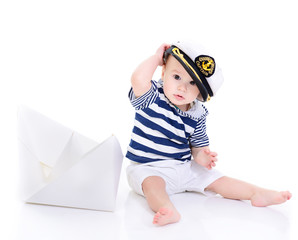 cute baby boy sitting in captain cap with ship of paper - sailor