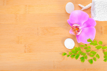 spa concept, lilac orchid and white towels on the bamboo backgro