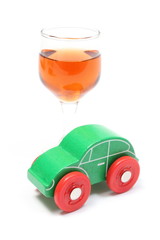 Glass of wine and wooden toy car. White background